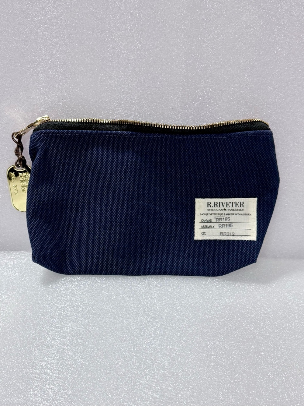R.Riveter Lucy Canvas Zipper Pouch features a gold-toned dog tag accessory